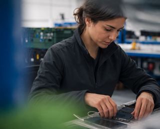 GuardComms technician preparing PTT radio devices for delivery